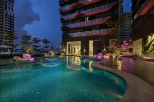 a swimming pool in front of a building at night at ARTEplus JALAN AMPANG KLCC in Kuala Lumpur