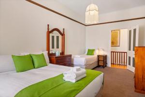 a bedroom with two beds with green and white sheets at Kallara House walk to restaurant strip in New Town