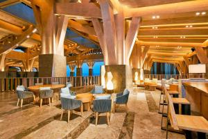 a restaurant with wooden ceilings and tables and chairs at The Westin Shimei Bay Resort in Wanning