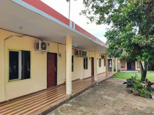 szereg domów z drewnianym tarasem w obiekcie RedDoorz Syariah near Terminal Alam Barajo Jambi w mieście Kinati +13 zdjęć