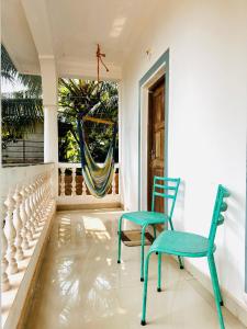 a porch with two chairs and a hammock at Tranquilo Arambol in Arambol