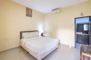 ein Schlafzimmer mit einem weißen Bett und einem Fenster in der Unterkunft Green Cottage Lembongan by ABM in Nusa Lembongan