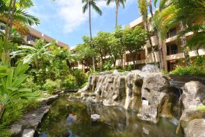 a garden with a pond in front of a building at Paki Maui 424 in Kahana