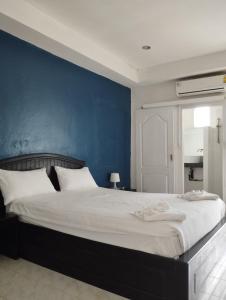 a bedroom with a large bed with a blue wall at SP.Place Hotel Koh Chang in Ko Chang