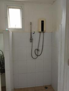 a shower in a white tiled bathroom with a window at SP.Place Hotel Koh Chang in Ko Chang