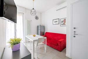 sala de estar con sofá rojo y mesa en Casa di Lolli, en Milán