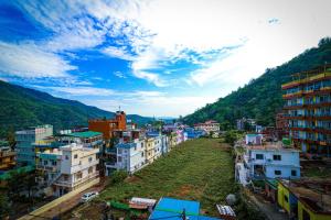 Blick auf eine Stadt mit Gebäuden und einem Berg in der Unterkunft Manzil Hostel in Rishikesh