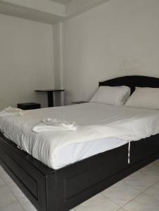1 cama grande con marco negro y sábanas blancas en SP.Place Hotel Koh Chang, en Ko Chang