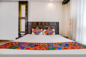 a bedroom with a bed with a colorful blanket on it at FabHotel Kingdom Sai in Shirdi