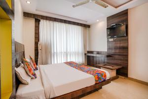 a bedroom with a bed and a television in it at FabHotel Kingdom Sai in Shirdi