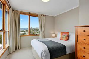 ein Schlafzimmer mit einem Bett und einem großen Fenster in der Unterkunft Poet s House 6br fabulous character WOW views in Hobart