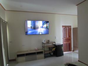 Sunrise Island في Ban Ko Sadao: غرفة معيشة مع تلفزيون بشاشة مسطحة على الحائط