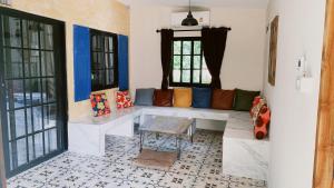 a living room with a bench and windows at Antani Home @Khaoyai in Pong Talong