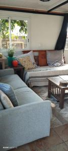 a living room with two couches and a table at Maison de charme, en Plaine Poésie -chez l'habitant- in La Plaine des Palmistes