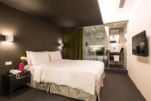 台北的住宿－凡登台北商務旅店，一间带大床的卧室和一间浴室