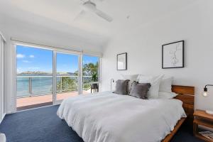 桑迪湾Sandy Bay Beachfront Oasis direct beach access的一间带大床的卧室，可欣赏海景