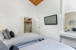 桑迪湾Sandy Bay Beachfront Oasis direct beach access的一间卧室，有两张床和一台挂在墙上的电视