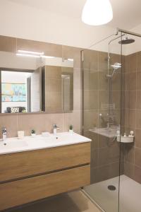 baño con 2 lavabos y ducha de cristal en Appartement La Balagne , Bord de mer, Grande Terrasse, Sant'Ambroggio, en Lumio