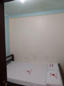 ein Schlafzimmer mit einem weißen Bett mit roter Schrift in der Unterkunft WJV INN Cordova in Cebu City