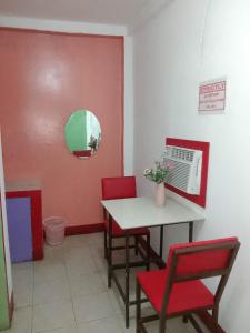 Zimmer mit einem Tisch, Stühlen und einem Spiegel in der Unterkunft WJV INN Cordova in Cebu City