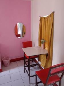 ein Esszimmer mit einem Tisch, Stühlen und einem Spiegel in der Unterkunft WJV INN Cordova in Cebu City