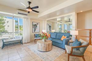 a living room with a blue couch and a table at Palms at Wailea 2108 in Wailea