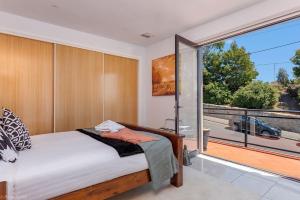 een slaapkamer met een bed en een groot raam bij The Artview fantastic city location os parking in Hobart