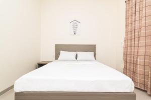 1 dormitorio con 1 cama grande con sábanas blancas en OYO Life 2735 Graha Nirwana en Tanjungriau