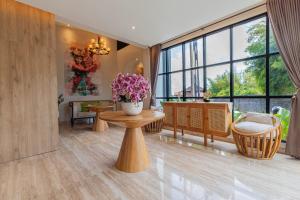 una sala de estar con un jarrón de flores sobre una mesa en The Baliem Hotel, en Jimbaran