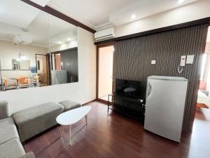 ein Wohnzimmer mit einem Sofa und einem TV in der Unterkunft Super Executive G Setiabudi 2BR 1BA - code 15 in Bandung