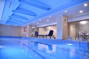 伊斯蘭堡的住宿－伊斯蘭堡萬豪酒店，一个带椅子和桌子的大型游泳池