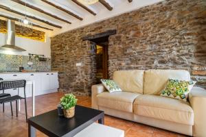 a living room with a couch and a stone wall at Paraje la Suerte Apartamento Dalia in Adra