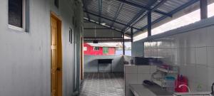 a kitchen with a red house in the distance at Deena Homestay in Ranau