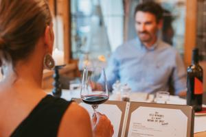a woman holding a glass of wine in front of a man at MANNI das Hotel in Mayrhofen
