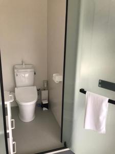 a bathroom with a toilet and a towel at glampark resort Akuna beach in Henza