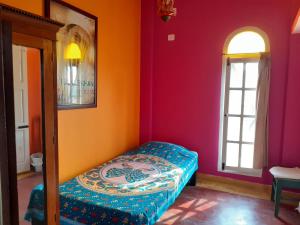 a small room with a bed in the corner of a room at Holi-Wood Guesthouse in Puducherry