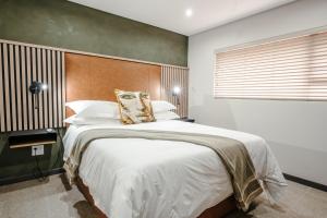 a bedroom with a large bed with a wooden headboard at 80 on Thabo in Potchefstroom