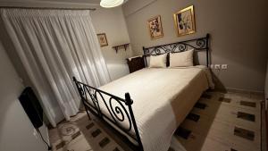 sypialnia z czarnym łóżkiem z białą narzutą w obiekcie Tripio Lithari - Arachova Vacation Home w mieście Arachova