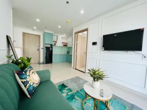 uma sala de estar com um sofá verde e uma televisão de ecrã plano em An homestay, apartment Nera Huế em Thôn Văn Dương