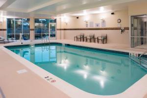una piscina con acqua blu in una camera d'albergo di Courtyard by Marriott Albany Clifton Park a Clifton Park