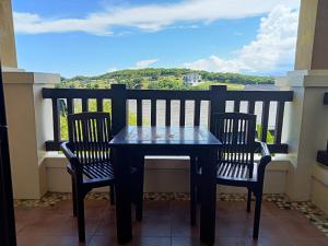 una mesa y sillas en un balcón con vistas en Keira 208, Alta Vista De Boracay, en Boracay