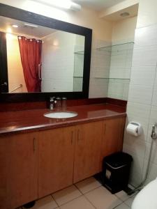 a bathroom with a sink and a large mirror at Keira 208, Alta Vista De Boracay in Boracay