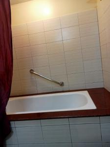 a bath tub in a bathroom with a towel rail at Keira 208, Alta Vista De Boracay in Boracay