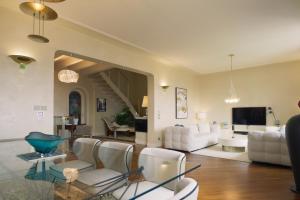 a living room with white furniture and a staircase at Villa Angela Luxury Relax in Desenzano del Garda