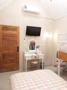 a bedroom with a bed and a desk and a tv at private khaoyai in Mu Si