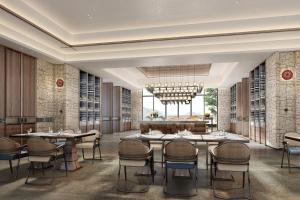 Courtyard by Marriott Liuzhou Sanjiang في Sanjiang: غرفة طعام بها طاولات وكراسي وثريا