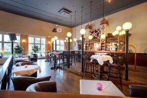 un restaurant avec des tables et des chaises ainsi qu'un bar dans l'établissement Strandhotel Preussenhof, à Zinnowitz