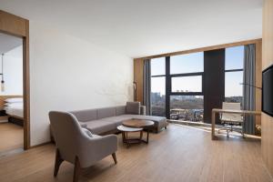 uma sala de estar com um sofá, uma cama e uma televisão em Fairfield by Marriott Guiyang Guanshanhu em Guiyang