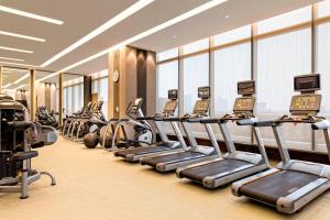 a gym with a row of treadmills and machines at Yiwu Marriott Hotel in Yiwu