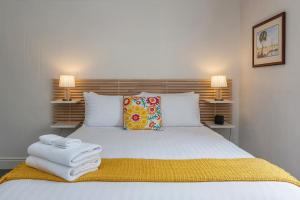 霍巴特Sir Tom inner city living with off street parking的卧室里有一张白色的床，床上放着毛巾